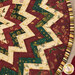 A close up on the table topper, demonstrating fabric colors and print details on the folded points.