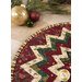 A close up on the table topper, demonstrating fabric colors and print details on the folded points with Christmas bulbs in the top left corner. 