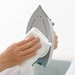 A model wipes the soleplate clean, demonstrating ease of use.