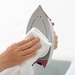 A model wipes the soleplate clean, demonstrating ease of use.