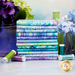 A stack of the fabrics included in the Hydrangea Dream collection, with flowers and jars and thead.