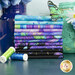 A stack of the fabrics included in the Evening Glow collection, with flowers and vases and a butterfly and thread.