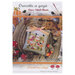 The front of pattern showing a picture of the completed autumn tiny village design staged with coordinating holiday decor.