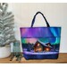 A Playing with Panels Market Tote colored in fabric showcasing a winter cabin under the aurora borealis, staged with coordinating decor.