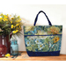 A Playing with Panels Market Tote colored in blue and green butterfly fabric, staged with coordinating decor.