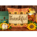 The finished Thankful pillow wrap kit, an orange and tan wrap with sunflower borders and appliqué letters that read 