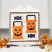 A Halloween-themed quilt featuring orange trick-or-treat buckets, purple and black candies, displayed on a white board.