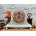 The fully assembled and painted Fleur Round Cross Stitch Frame, staged on a white tabletop next to sewing notions, displaying a festive cross-stitch project.