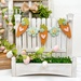 The fully assembled and painted Picket Perch Displays, staged on a white tabletop with coordinating greenery and spring décor, displaying Easter decorations.