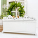 The fully assembled and painted Tiny Town Rooftops Cross Stitch Display, staged on a white tabletop with coordinating greenery in the background.
