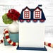 The fully assembled and painted Patriotic City House #3 Cross Stitch Display, staged on a white tabletop with coordinating patriotic décor and flowers.