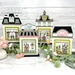 The fully assembled and painted City building Cross Stitch Display Backers, staged on a white marble countertop with coordinating spring greenery.