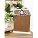 The fully assembled and painted All Seasons Gingerbread House Cross Stitch Display, staged on a wooden tabletop with complementary greenery and décor.
