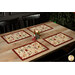 A wide shot of the four placemats on a wooden table with coordinating Christmas décor.