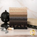 A stack of the fabrics included in the Black Sheep Cottons collection, with a cast iron yarn dispenser and books and thread.