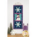 The completed January project, depicting two snowflakes and a jolly snowman, hung on a craft hanger against a white paneled wall and staged with coordinating winter decor.