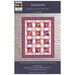 Horizons quilt by Down to the Letter displayed on a brick wall, featuring geometric patterns.