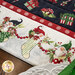 A super close up on one part of the runner, showing details on the christmas themed fabric used as the border print, featuring gnomes in stockings. 