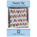 The front of the Steppin' Up quilt pattern displaying the finished product against a wood fence.
