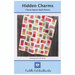 The front of the Hidden Charms quilt pattern displaying the finished product against a wood fence.