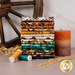 A stack of the fabrics included in the Canyonlands collection, with a candle and wheat and hay and a wagon wheel and thread.