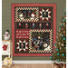 The completed Let it Snow quilt, colored in red, black, cream, and green flannels from the Holly Jolly fabric collection, hung on a green paneled wall, the quilt is staged with coordinating winter themed decor and furniture.