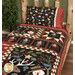 A shot of the completed quilt staged on a wood log bed with the coordinating pillow.