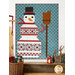 The completed Patchwork Snowman quilt colored in the cool winter teal, red, and white of the Frosty and Forest Friends collection, hung on a white shiplapped wall and framed by coordinating winter décor.