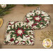 A stylized image of a round and square hot pad with a festive star design in red, white, and green, surrounded by holiday decor.
