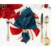 A top down shot of one of the napkins with the dark teal blue fabric facing outward, staged on a red and white candy cane striped plate on a white table with coordinating tableware.