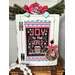 A decorated cabinet with a festive Joy to the World sign, wreath, and pine garland.