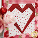 A stylized close up on one of the heart blocks, showing details on the fabric colors and prints as coordinating décor peeks into frame from the left side.