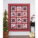 The completed Snow Crew Besties Quilt, colored in red, white, gray, and black fabrics from the Snow Crew Flannel collection, hung on a white paneled wall and staged with coordinating decor like a decorated tree, and a snowman figurine.