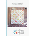 Cover of Twisted Star quilt pattern featuring a colorful quilt design against a brick wall.