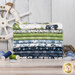 A stack of the fabrics included in the Nantucket Summer Quilting Cuddle FQ Bundle, with seashells and netting and a shipwheel and thread.
