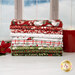 A stack of the fabrics included in the Christmas Eve Quilting Cuddle collection, with a window and snow and a mug with marshmallows and a poinsettia.