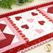 A close up on the center of the small table topper, showing off the laser cut hearts and scallop borders. 