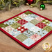 A stylized, angled shot of the hot pad, staged on a wooden table with coordinating ornaments and a garland.