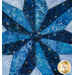 A top down close up on the center of the patchwork star, demonstrating piecing and print details, especially on the silver metallic accents of the blue fabrics.