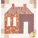 A super close up on a single patchwork house from the project, showing fabric print details on the purple, orange, and cream fabrics, as well as top quilting effects.