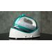 A teal and white Panasonic steam iron resting in its plastic base on a dark surface.