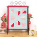 The completed Tender Heart Tabletop Banner, a series of pink and white patchwork hearts on a blue mottled fabric, staged with coordinating décor.