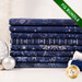 A stack of the eight fabrics included in the 8 FQ Bundle Dark Blue/Silver by Stof Fabrics, staged with thread and ornaments.