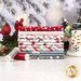A stack of the fabrics included in the Snow Folks collection, with trees and snow and cardinals and a snowman and thread.