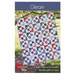 The front of the Gleam pattern featuring a red, white, and blue quilt with a sawtooth star pattern hung on a tree branch in a natural setting.