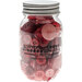 Glass jar filled with various red and pink buttons, labeled Buttons Galore & More.
