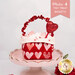 One of the Tiny Treat Baskets, colored in bold pink, red, and cream fabrics from the Darling Peony collection by Moda Fabrics, staged on a pink cake plate and filled with candy hearts. A banner in the top right reads "Makes 4 Tiny Treat Baskets!"