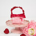 A single Tiny Treat Basket, staged on a pink cake plate with coordinating Valentine's Day themed décor.