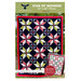 A dynamic quilt featuring a star patchwork pattern in various fabrics, titled Star of Wonder.