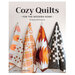 The front of Cozy Quilts for the Modern Home book featuring a quilted hanging on a light colored wall.
